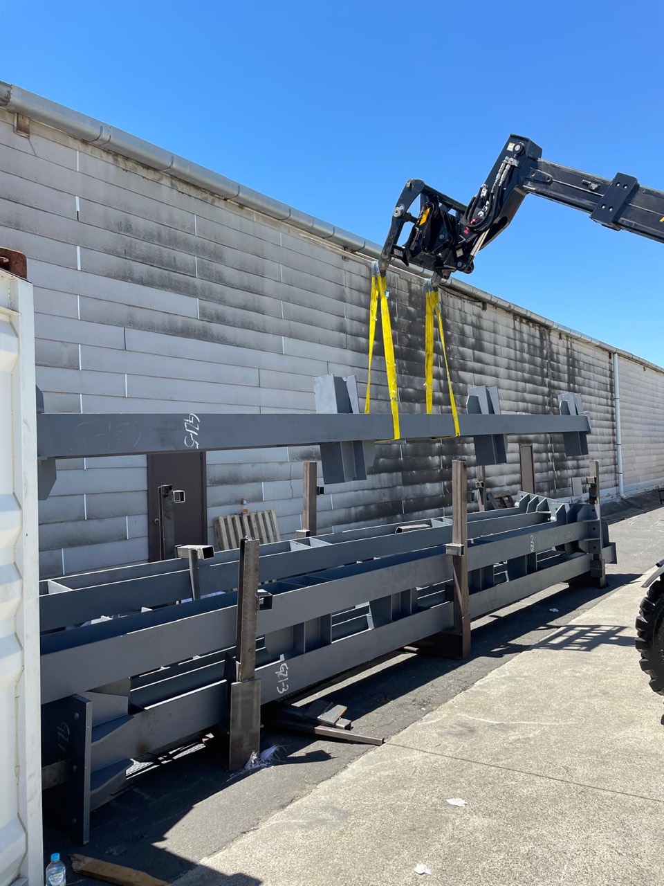 Industrial steel components being lifted in a yard